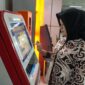 Seorang penumpang sedang mengisi ulang KMT (Foto: KAI)