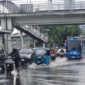 Personel Brimob, Lantas, dan Polair PMJ mengevakuasi warga dan mengatur lalu lintas di lokasi banjir Jakarta