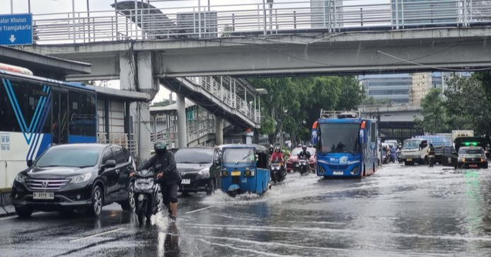 Personel Brimob, Lantas, dan Polair PMJ mengevakuasi warga dan mengatur lalu lintas di lokasi banjir Jakarta