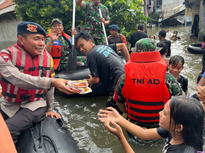 
Personel Brimob Polda Metro Jaya mengevakuasi warga yang terdampak banjir di wilayah Jakarta Timur.