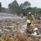 Petugas Damkar memadamkan kebakaran tumpukan sampah di Kramat Jati.