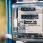 Petugas mencatat meter listrik PLN di rumah pelanggan.