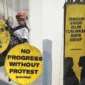 Enam aktivis Greenpeace membentangkan spanduk protes di Monumen Selamat Datang Bundaran HI